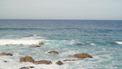 atlantic ocean waves crushing into the stone beaches of madeira island, portugal.