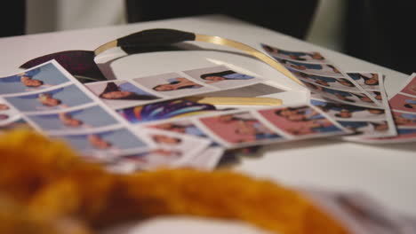 Close-Up-Of-A-Group-Of-Friends-Having-Fun-Looking-At-Prints-From-Photo-Booth-With-Props-3