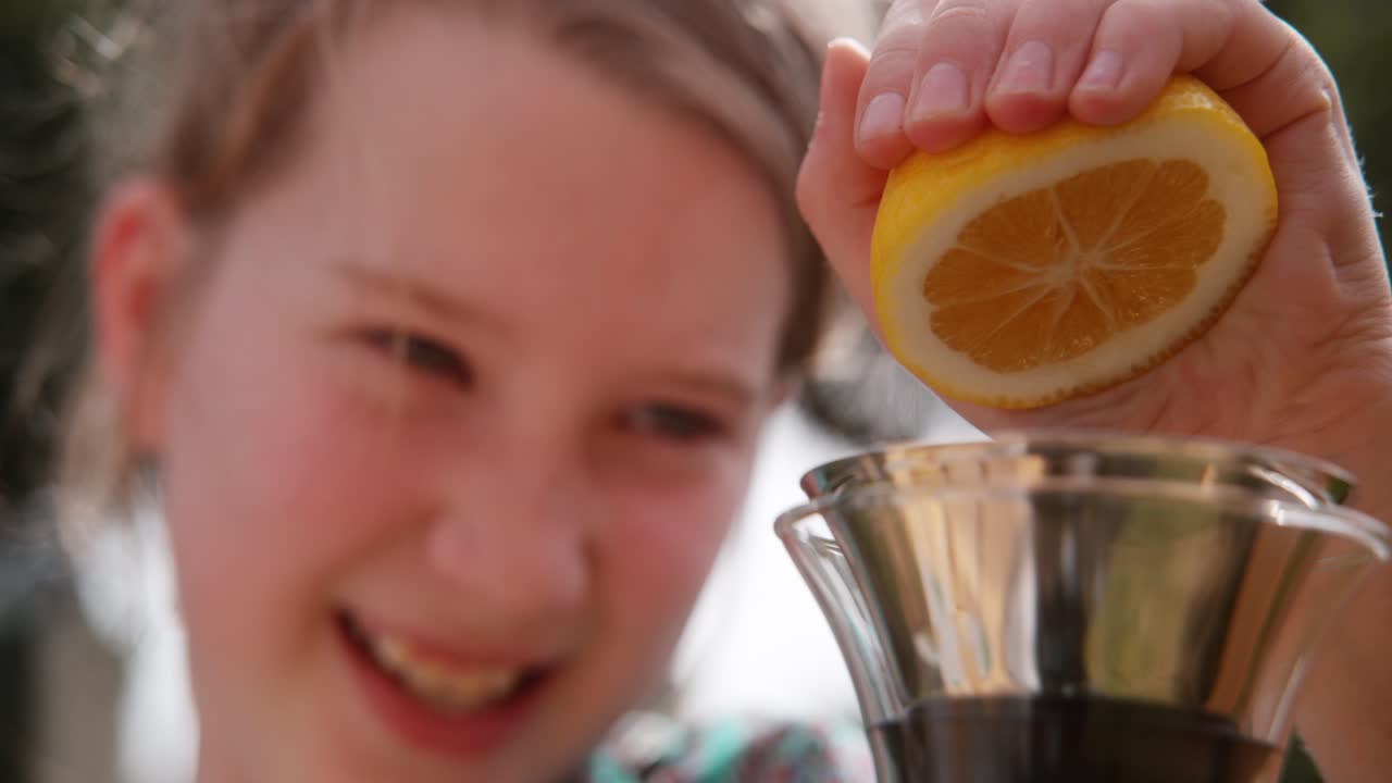 Young girl squeezes lemon halve to make lemonade one hand 1000 fps Phantom