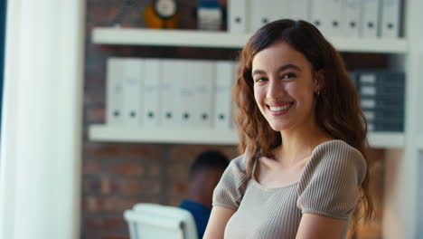 Portrait-Of-Young-Smiling-Businesswoman-Working-In-Modern-Office