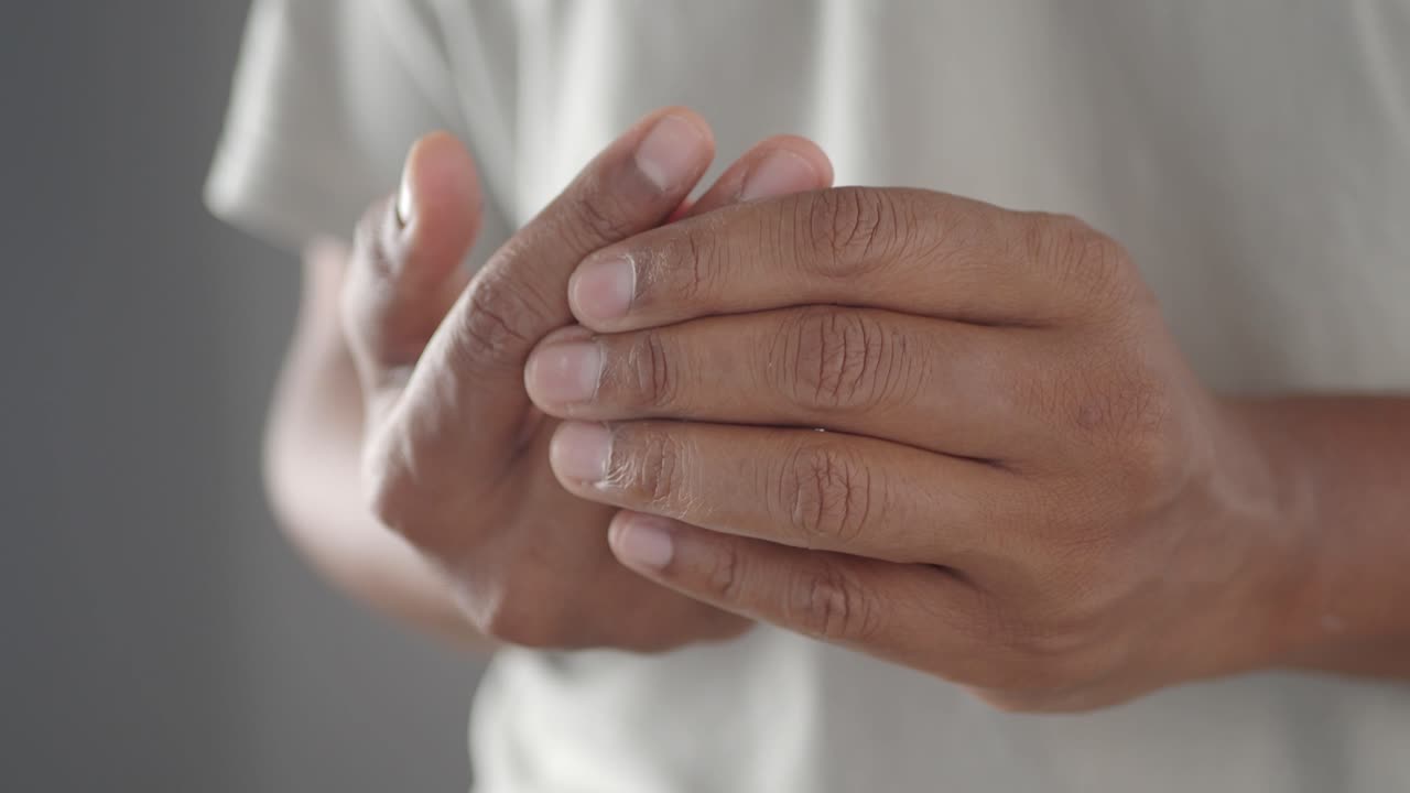 Primo piano di una persona che si sfrega le mani a causa del dolore articolare