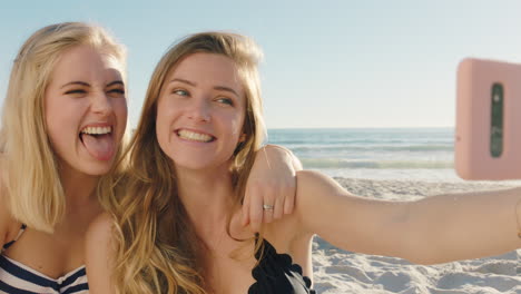 Amigas-Tomando-Fotos-Selfie-Usando-Un-Teléfono-Inteligente-En-La-Playa-Divirtiéndose-Compartiendo-Vacaciones-De-Verano-Disfrutando-Del-Verano-Junto-Al-Mar