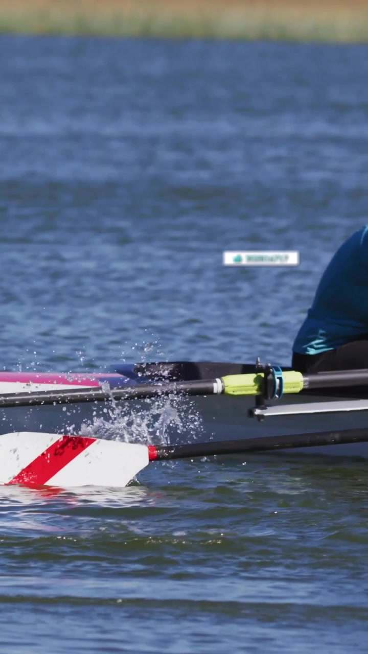 Vertical video: Male rower pulling oar in sports regatta, panning HUD tags tracking boats