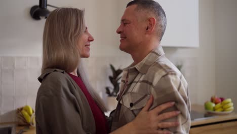una pareja feliz bailando en la cocina.