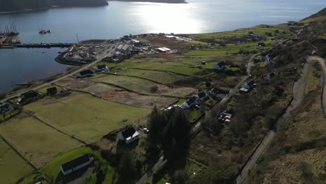 Calm-Highland-fishing-port-at-Idrigil-Bay-Uig-Isle-of-Skye-Scotland-with-slow-pan-up-reveal-of-distant-misty-mountains