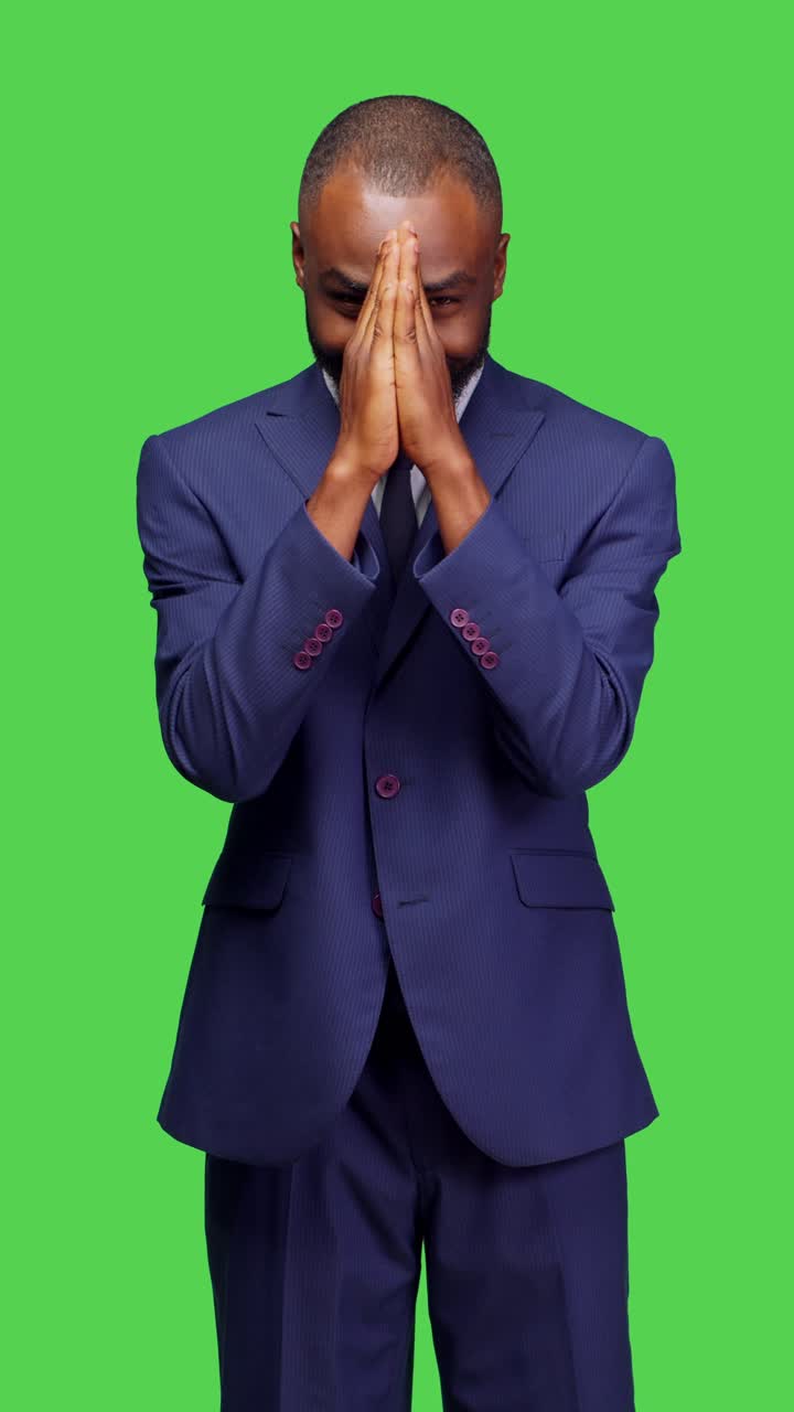 Vertical video: Front view of religious male model doing prayer hands symbol