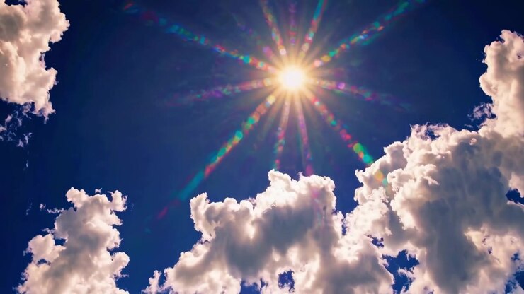 Bright Sun Shining Through White Clouds in Blue Sky