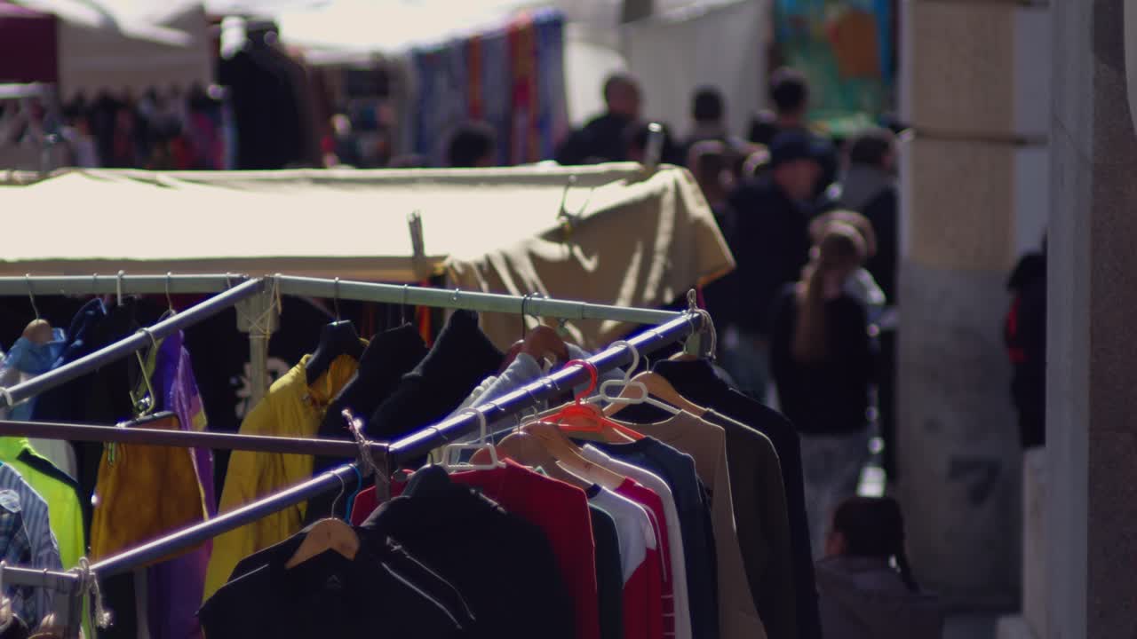 Stender con capi d'abbigliamento in un vivace mercato all'aperto