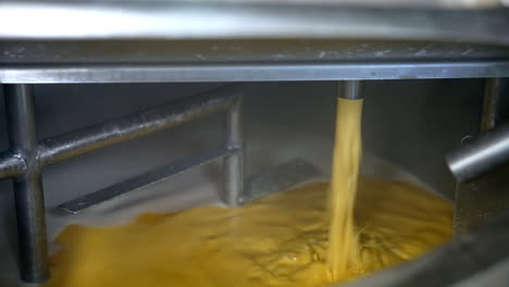 yellow liquid pouring into container. butter or cream production line. food industry production. dairy product manufacturer.