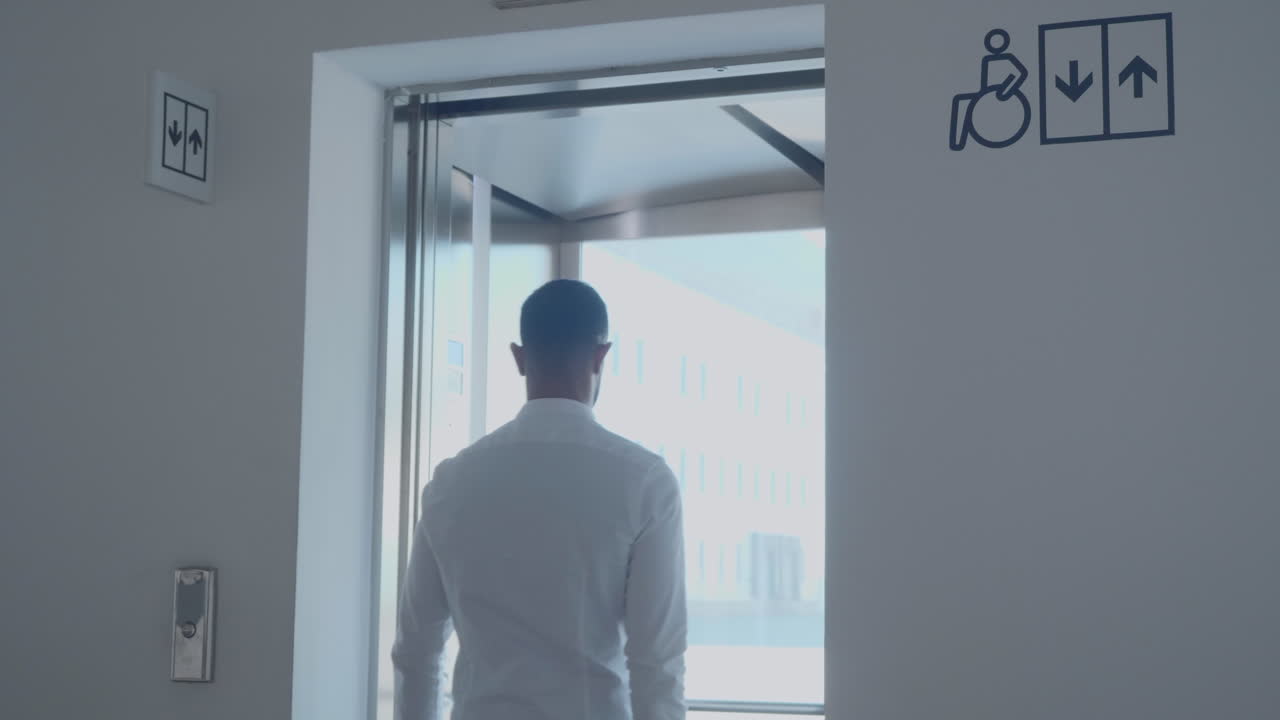 장애인 접근이 가능한 엘리베이터에 들어가는 남자