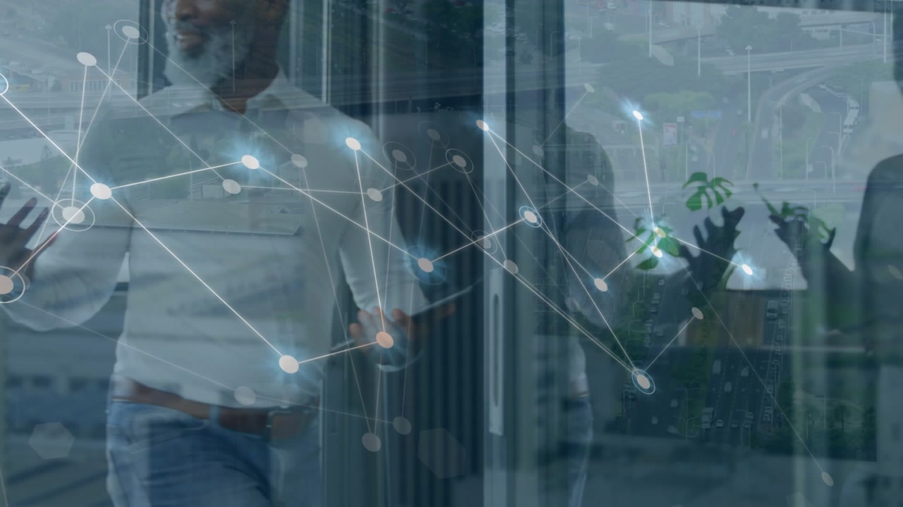Animation of connected dots, aerial view of city over diverse coworkers discussing in office