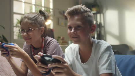two kids playing video games on a couch