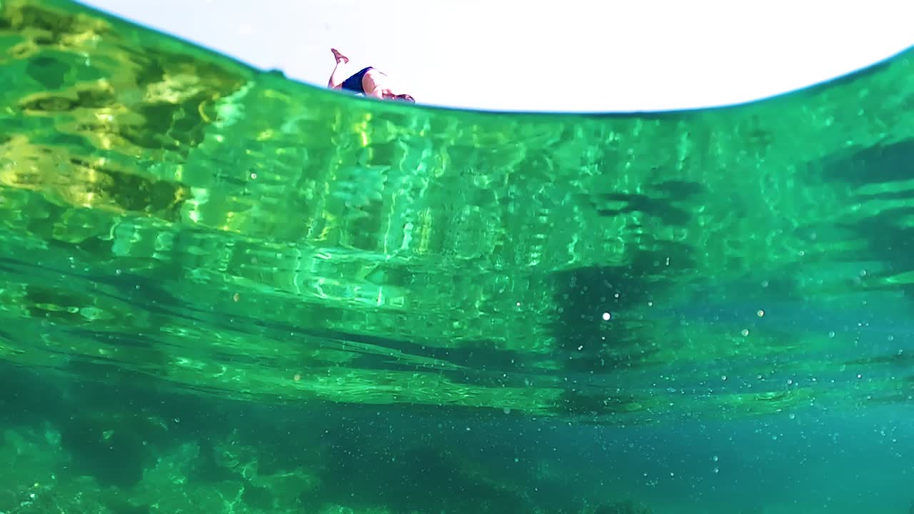 지중해 해안선 근처의 에메랄드색 잔잔한 바닷물에 기포를 방출하는 젊은 다이버