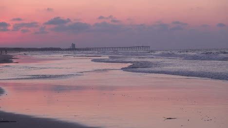 el sol sale sobre la playa al atardecer atrapando la marea entrante