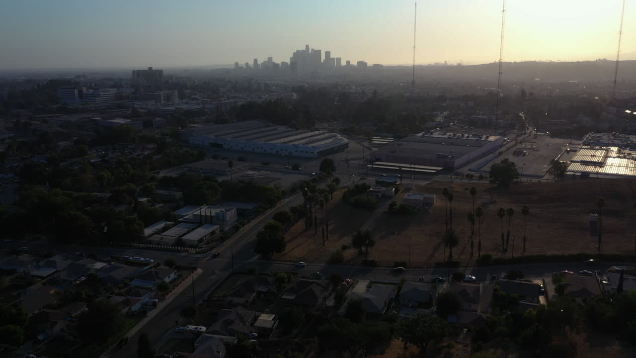 Ripresa a gru in salita del centro di Los Angeles con torri radio in primo piano durante un tramonto mozzafiato, California, USA.