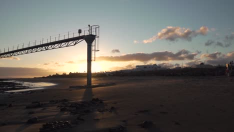 escena de la playa al atardecer con el muelle