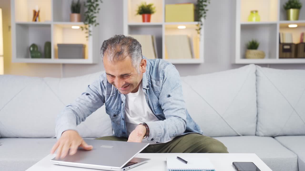 hombre abrazando alegremente el portátil.