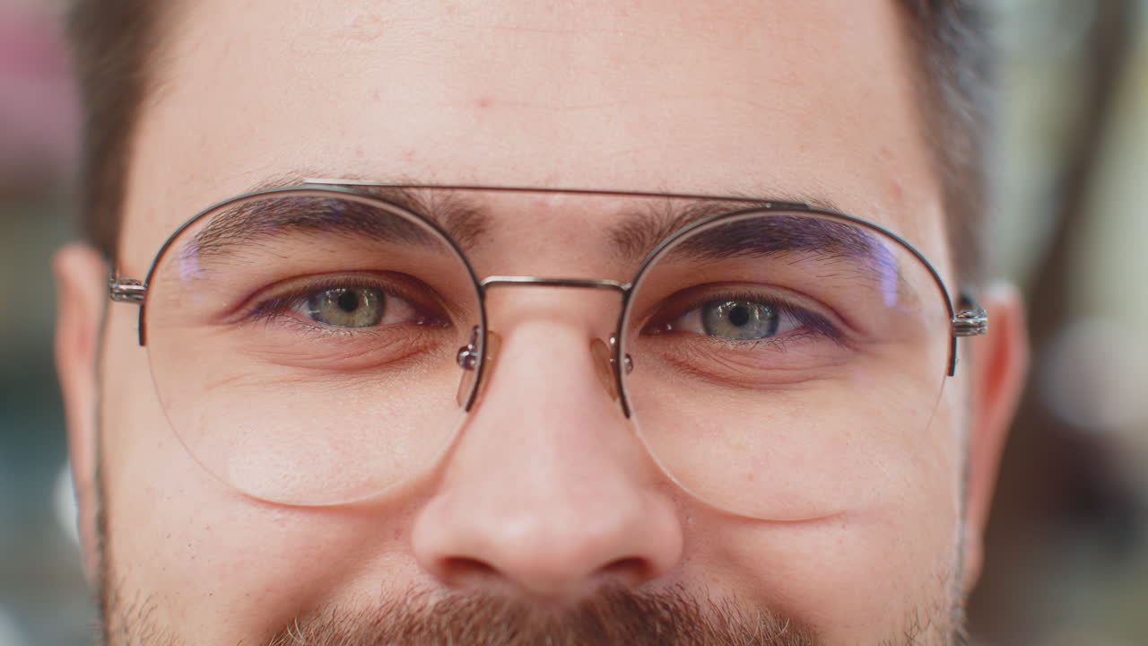 retrato macro de primer plano de un joven atractivo natural con gafas y ojos grises mirando a la cámara