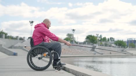 persona con discapacidad física que utiliza silla de ruedas para pescar en el muelle de pesca