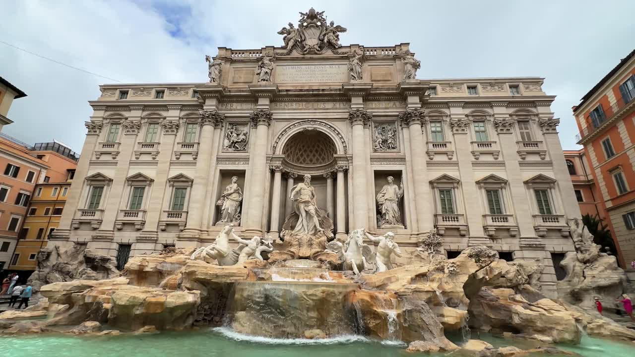 Up close centered view of Trevi Fountain or fontana, marble or stone facade of historic building on a Rome cloudy day