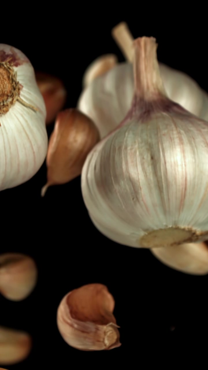 Bulbi e spicchi d'aglio freschi che salgono al rallentatore