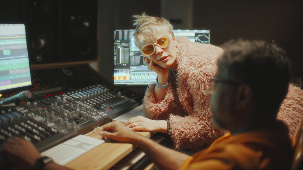 Female Singer Discussing Music with Sound Engineer in Recording Studio