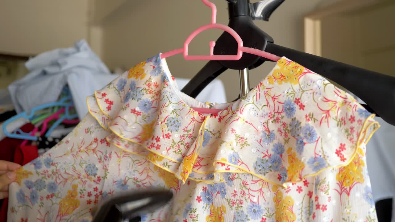 슬로우 모션 장면으로 집에 있는 스트림 다리미로 옷을 다림질하는 여성의 근접 촬영