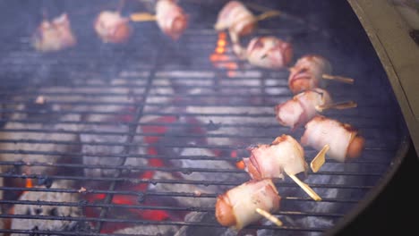 bacon-wrapped hot dogs on the grill