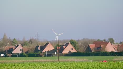 win turbine rotating behind a small french lot