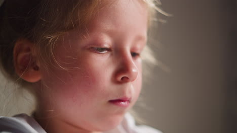 little girl artist draws picture on beige background closeup