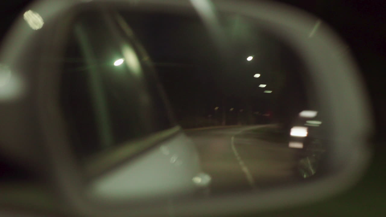 vista borrosa desde las ventanas laterales de un camión blanco de lujo con paisaje urbano de tráfico urbano por la noche