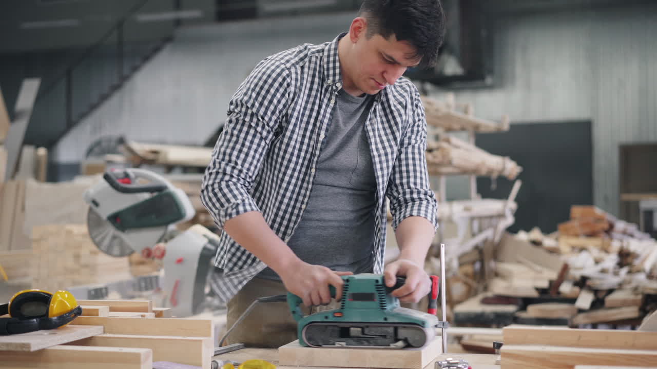 Man sanding wood in a woodworking shop