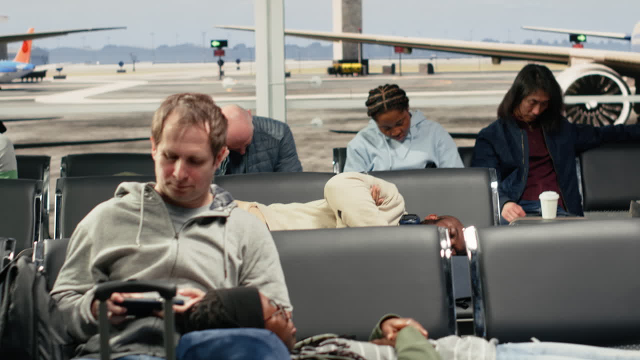 Tired tourists in airport sleeping on chairs after flights got cancelled