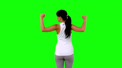 Woman-in-sportswear-tensing-her-arms-on-green-screen