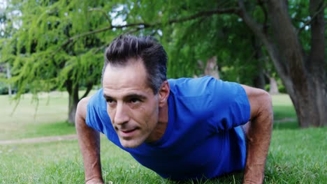 mature man doing push-up in the park