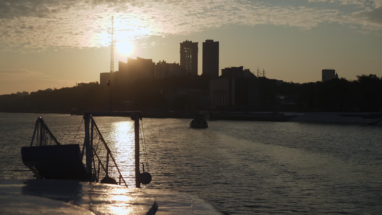 Silhouetted City Skyline and Water at Sunrise or Sunset from a Boat