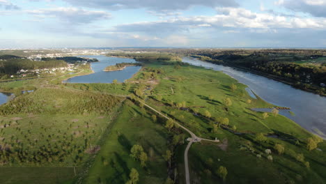 Paisaje-Verde-Y-Vibrante-Con-El-Río-Nemunas-Y-La-Ciudad-De-Kaunas-En-El-Horizonte,-Vista-Aérea-De-Drones