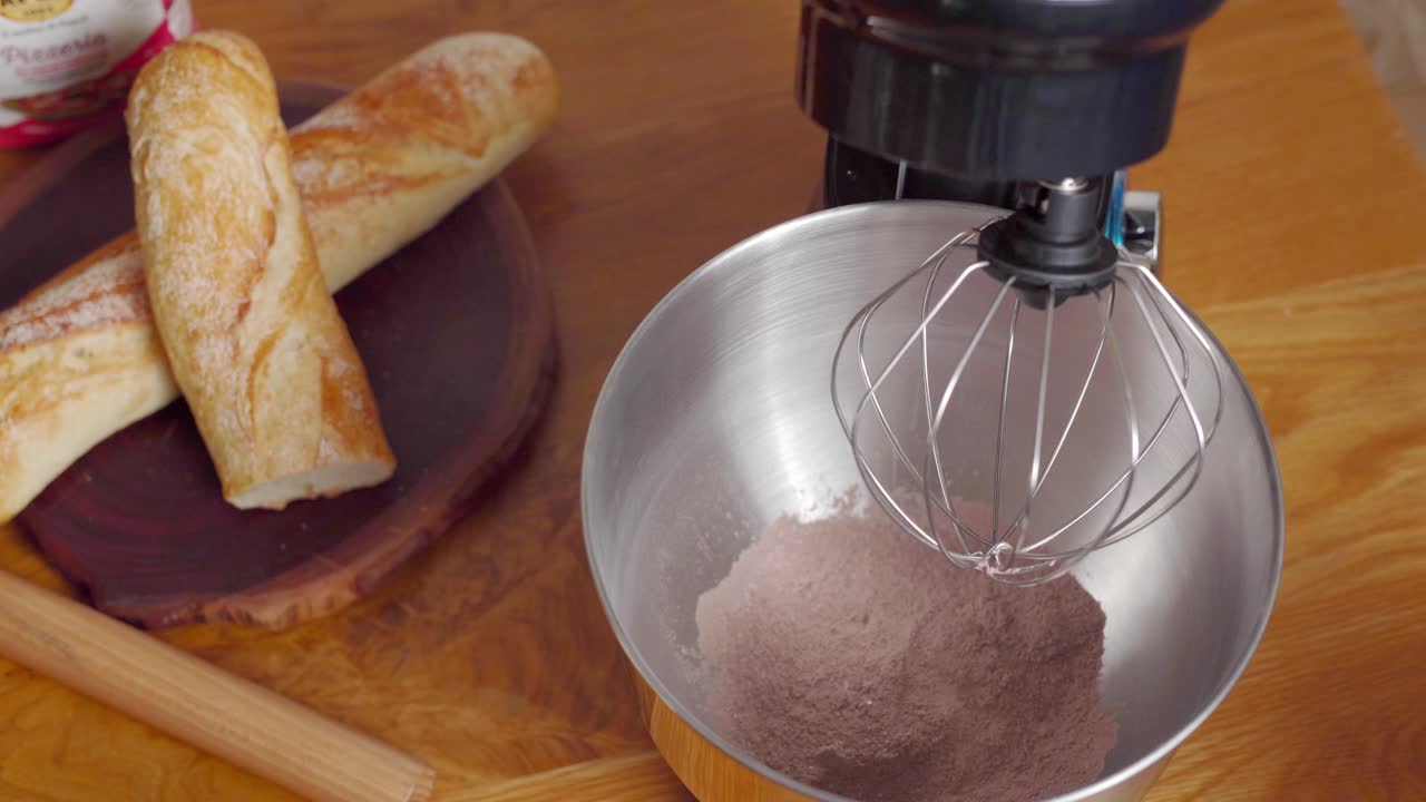 Mixing ingredients for cake batter, tabletop mixer lowered into bowl