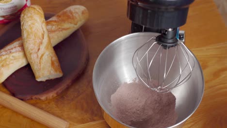Mixing-ingredients-for-cake-batter,-tabletop-mixer-lowered-into-bowl