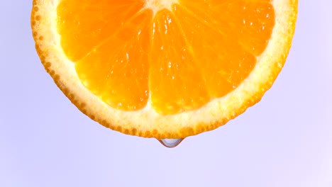 water or oils dropping on an orange slice , fruit for diet and healthy food