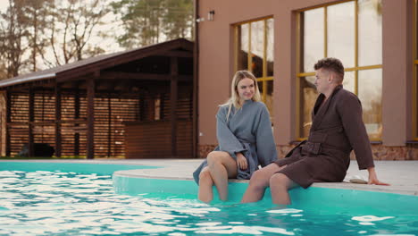 man and woman are relaxing in open swimming pool of modern recreation complex in ecological natural place