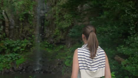 Modelmädchen-Blickt-Auf-Einen-Wasserfall-Im-Dschungel-Auf-Madeira,-Portugal,-Tief-Im-Grünen-Wald