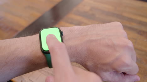 vista frontal de un hombre usando un apple watch con pantalla verde