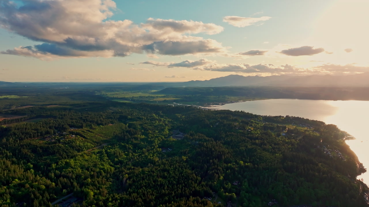 Drone footage over Hood Canal reveals tranquil water, wooded shoreline, and the natural beauty of the Olympic Peninsula from above.