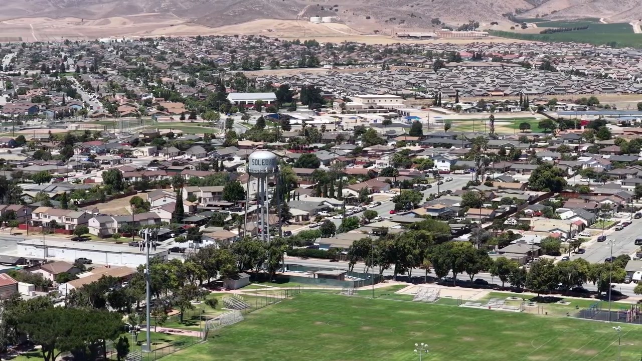 Kaliforniya, Monterey County'deki küçük bir kasaba olan Soledad'ın, karakteristik su kulesi ve engebeli tepeler ile tarım alanları arasına kurulmuş yerleşim evleriyle havadan görünümü