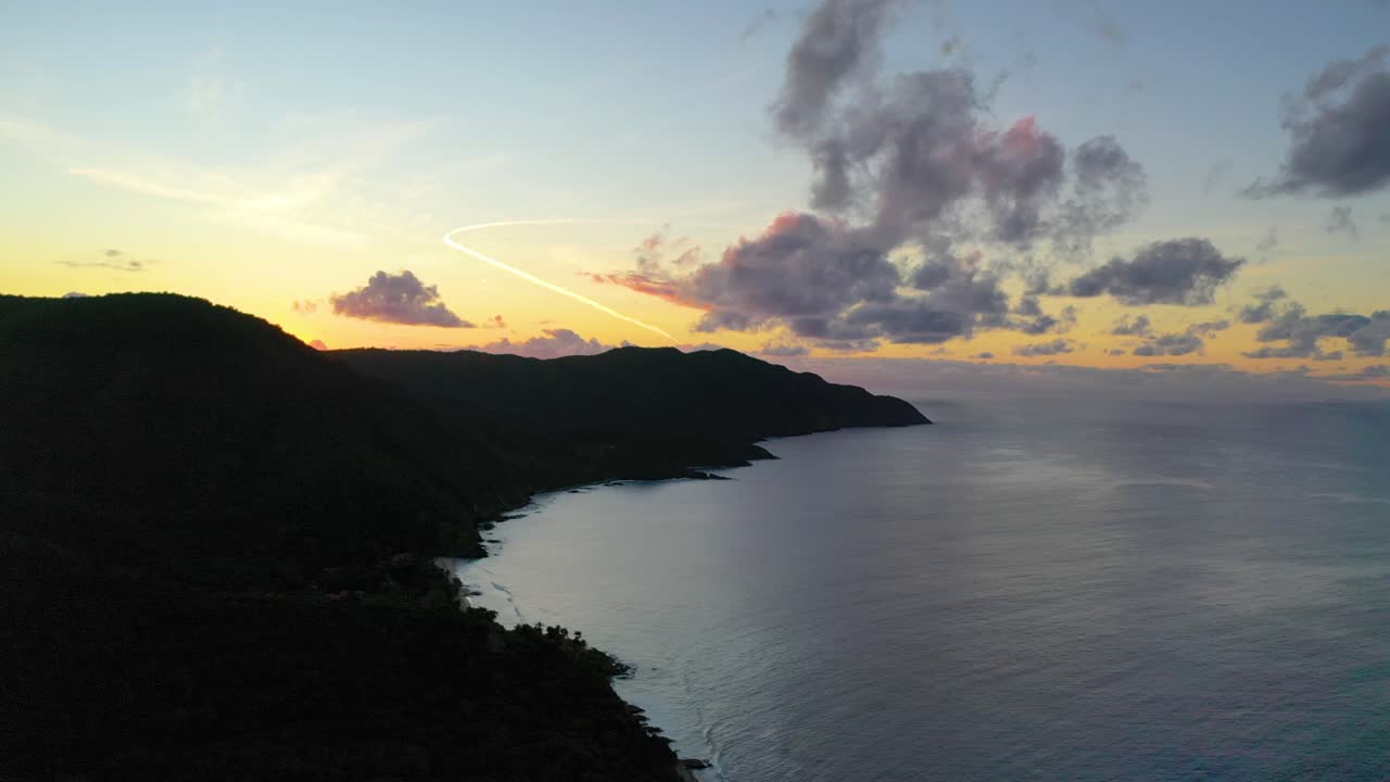 Stunning aerial drone captures a colorful sky above St. Croix’s coastline, where the calm sea reflects brilliant hues and a scenic peninsula juts peacefully into the ocean