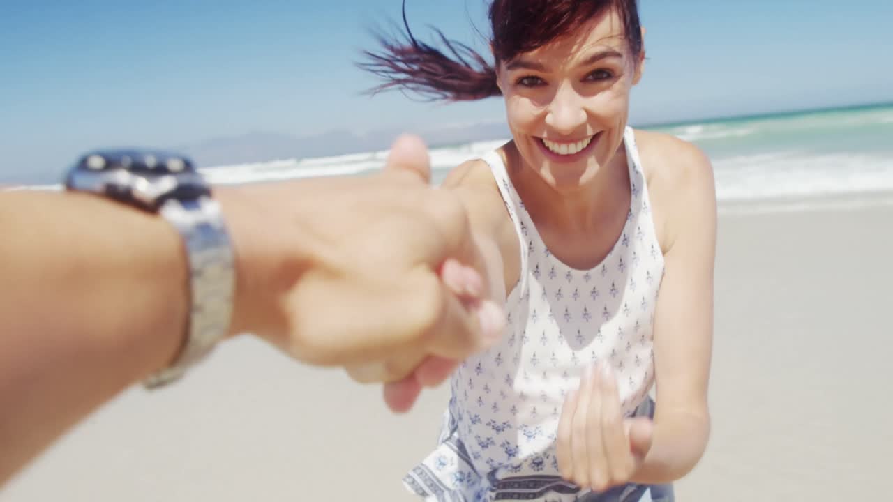 una pareja divirtiéndose en la playa.