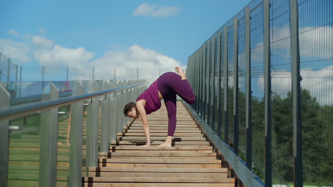 Woman practicing yoga on outdoor stairs