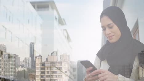 Animación-De-Una-Mujer-Asiática-Sonriente-Con-Hijab-Usando-Un-Teléfono-Inteligente-Sobre-El-Paisaje-Urbano