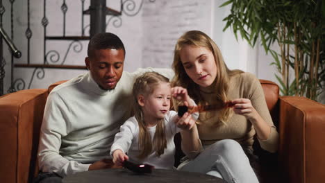 man woman and little girl look at negatives in living room